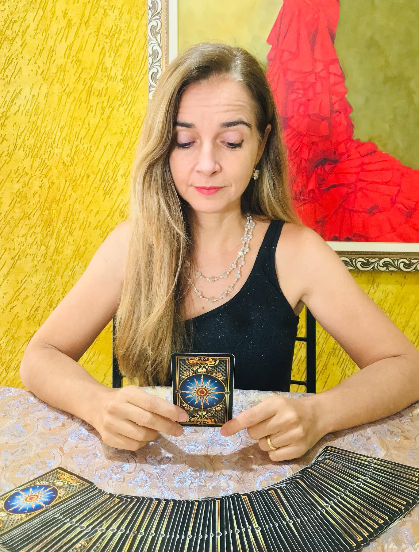 Anna Paula Goncalves analisando cartas de tarot sentada
